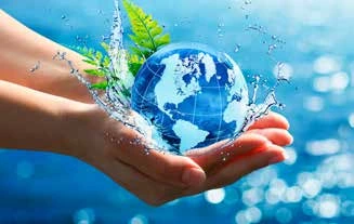 Manos que sostienen un globo terráqueo entre gotas de agua