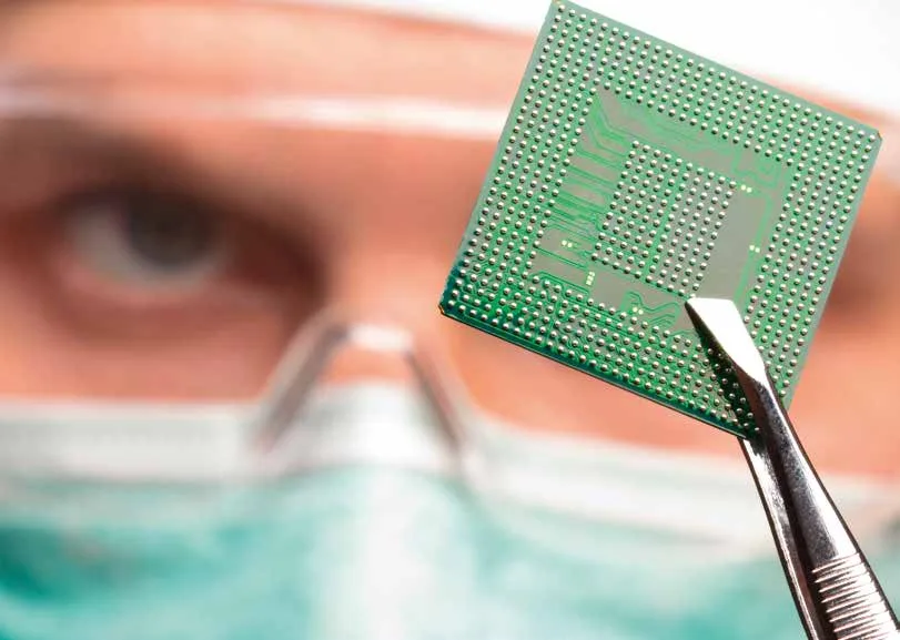Técnico con un microprocesador y pinzas